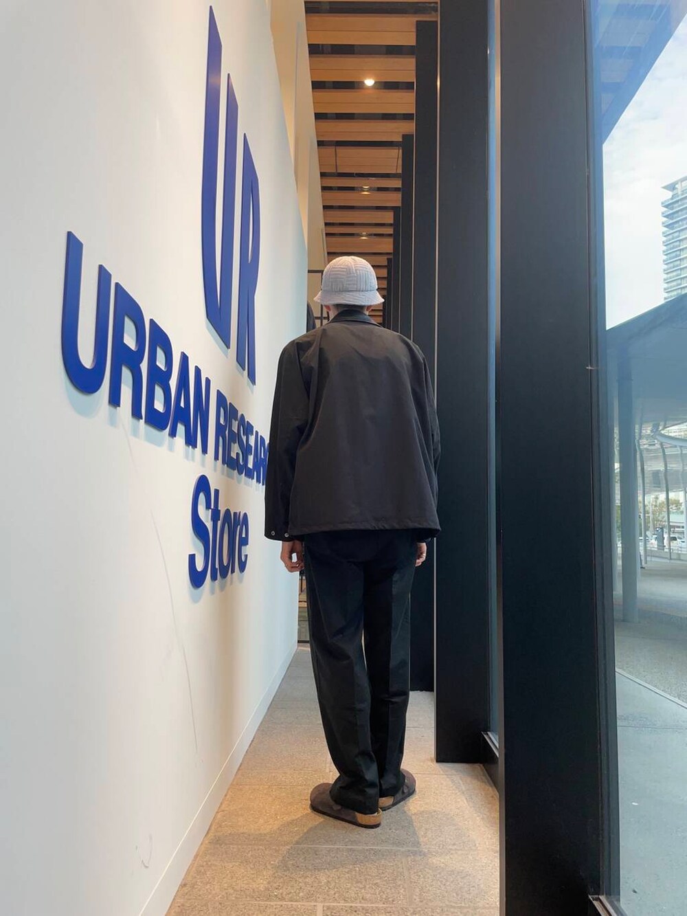 ブラック系のその他パンツ、ブラック系のその他アウター、グレー系のサンダルを着用したメンズの秋コーディネートの3枚目の写真