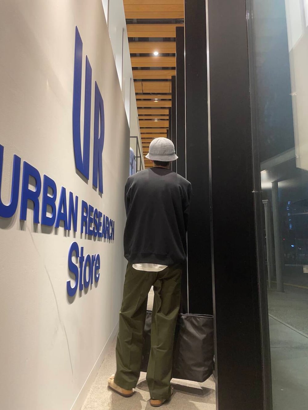 ブラック系のトートバッグ、ベージュ系のサンダル、グリーン系のその他パンツを着用したメンズの秋コーディネートの4枚目の写真