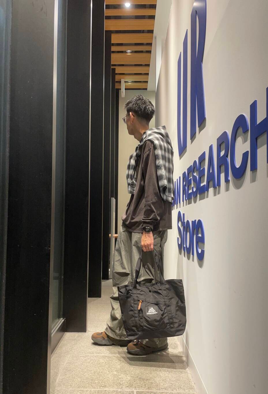 ブラック系のトートバッグ、ブラック系のシャツ/ブラウス、ブラウン系のTシャツ/カットソーを着用したメンズの秋コーディネートの3枚目の写真