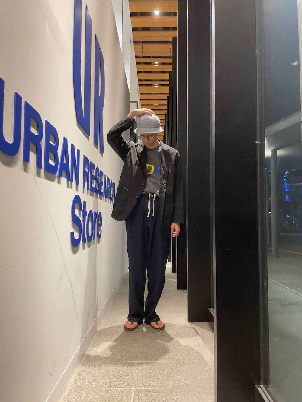 ブラック系のサンダル、ブラック系のその他アウター、ブルー系のデニムパンツを着用したメンズの夏コーディネートの4枚目の写真