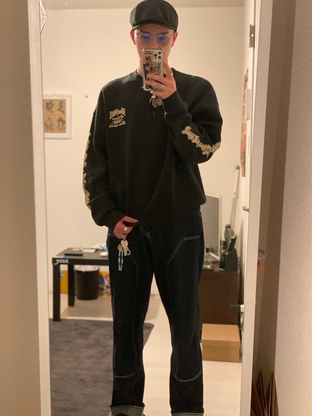 ブラック系のスウェット、ブルー系のデニムパンツ、ブラック系のドレスシューズを着用したメンズの秋コーディネートの2枚目の写真