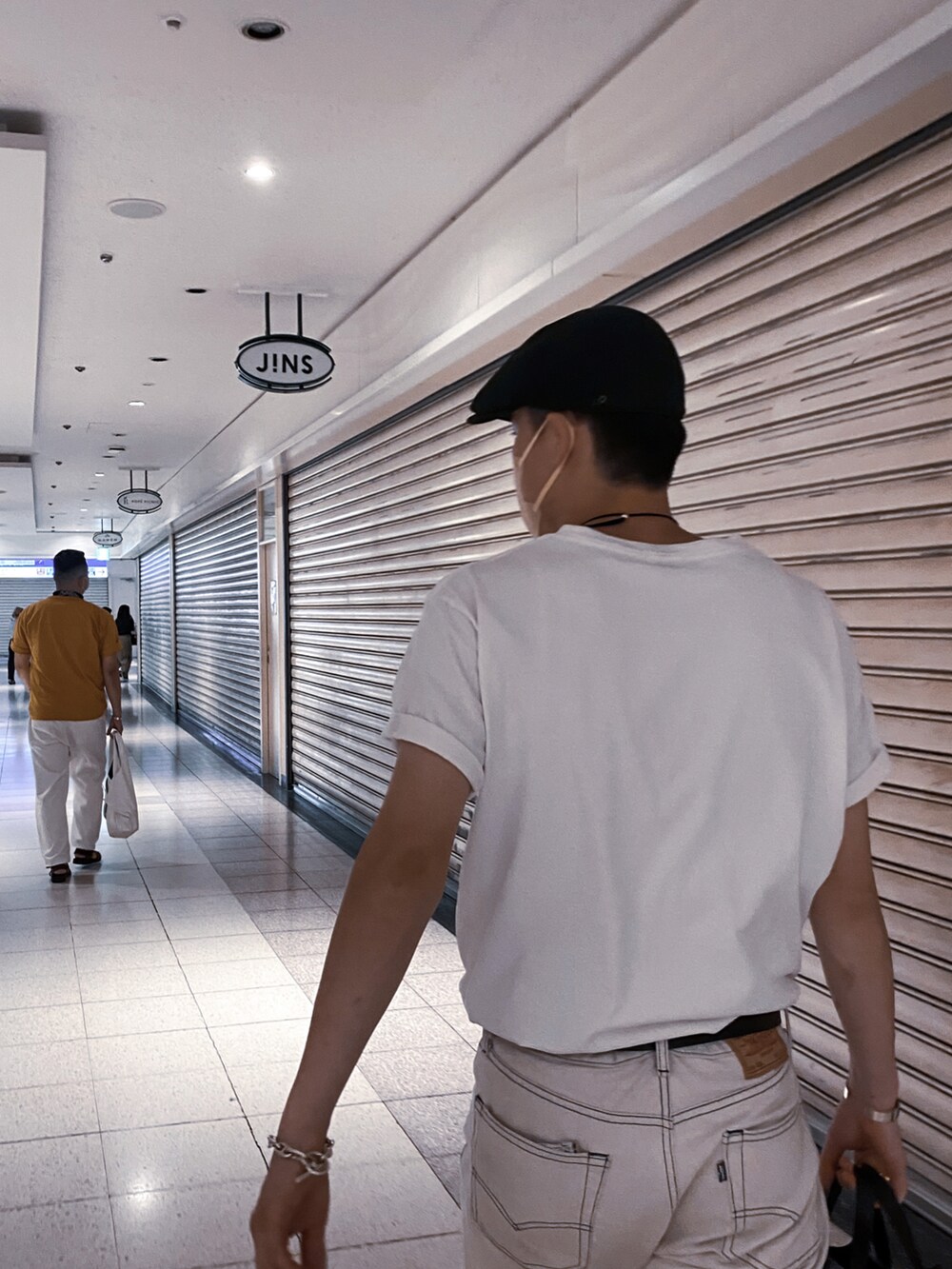 ホワイト系のTシャツ/カットソー、ホワイト系のデニムパンツ、ブラック系のトートバッグを着用したメンズの夏コーディネートの2枚目の写真