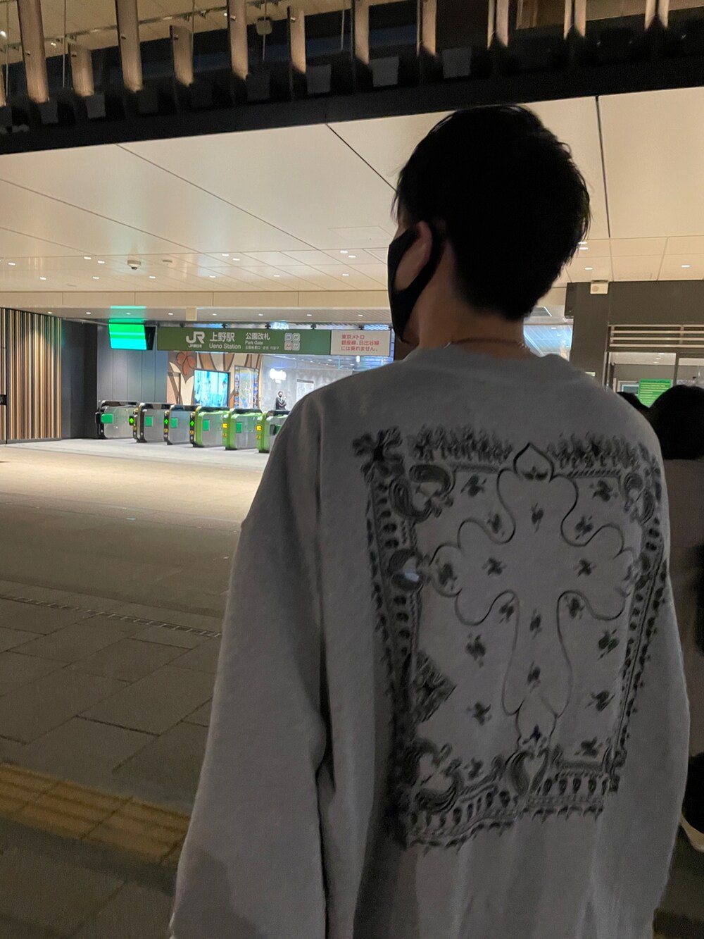 グレー系のスウェット、ブラック系のデニムパンツ、ブラック系のドレスシューズを着用したメンズの秋コーディネートの2枚目の写真