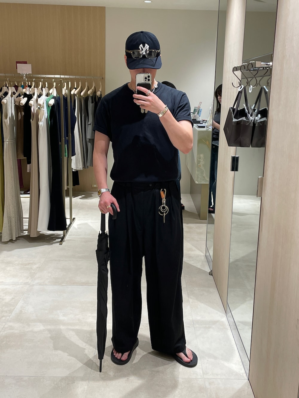 ブラック系のTシャツ/カットソー、ブラック系のスラックス、ブラック系のサンダルを着用したメンズの夏コーディネートの2枚目の写真