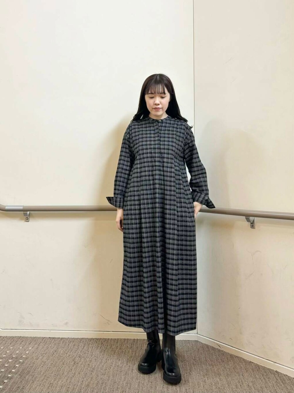 ブラック系のブーツ、ブラック系のワンピース、ホワイト系のその他アウターを着用したレディースの秋コーディネートの4枚目の写真