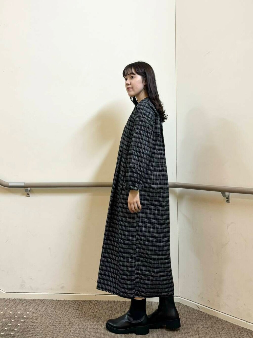 ブラック系のブーツ、ブラック系のワンピース、ホワイト系のその他アウターを着用したレディースの秋コーディネートの3枚目の写真