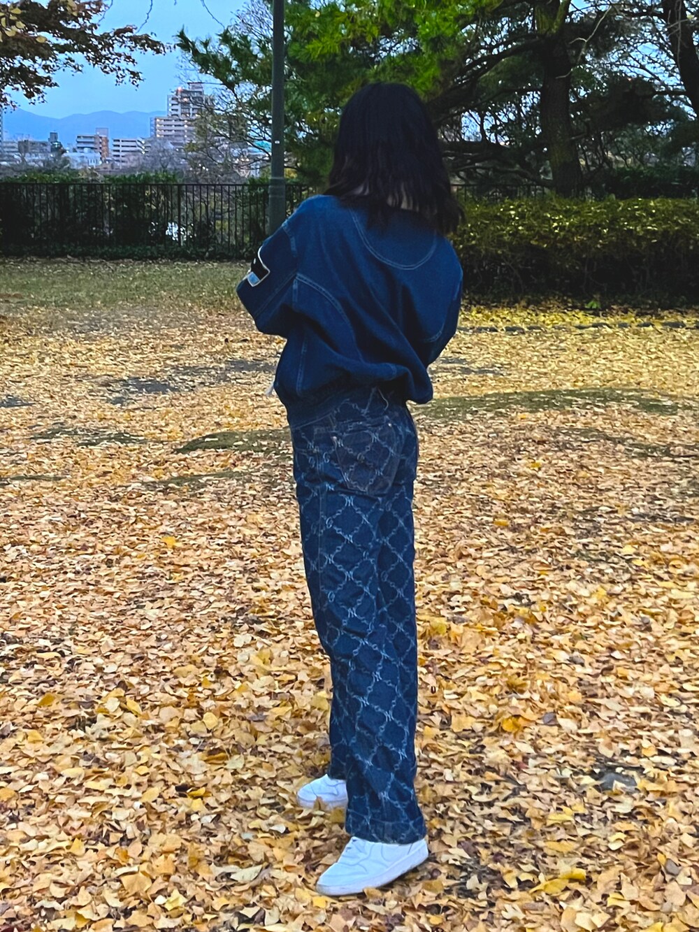 ホワイト系のバッグ、ブルー系のパンツ、ホワイト系のスニーカーを着用したレディースの冬コーディネートの3枚目の写真