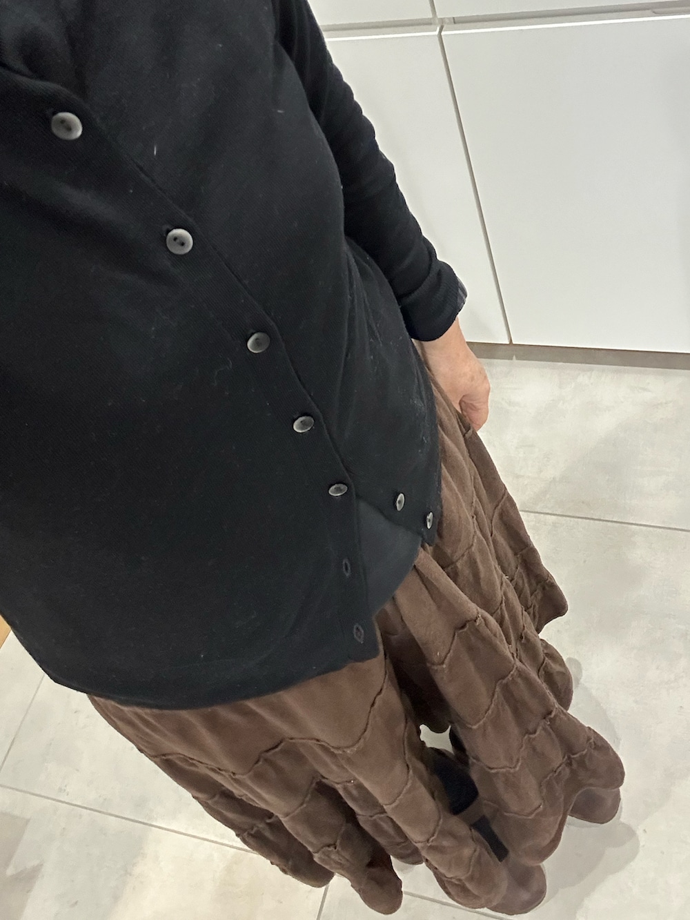 ブラック系のTシャツ/カットソー、ブラック系のカーディガン/ボレロ、グリーン系のダウンジャケット/コートを着用したレディースの冬コーディネートの2枚目の写真