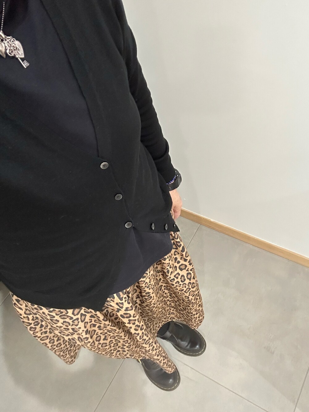 ブラック系のノーカラーコート、ブラック系のカーディガン/ボレロ、ブラック系のTシャツ/カットソーを着用したレディースの秋コーディネートの2枚目の写真