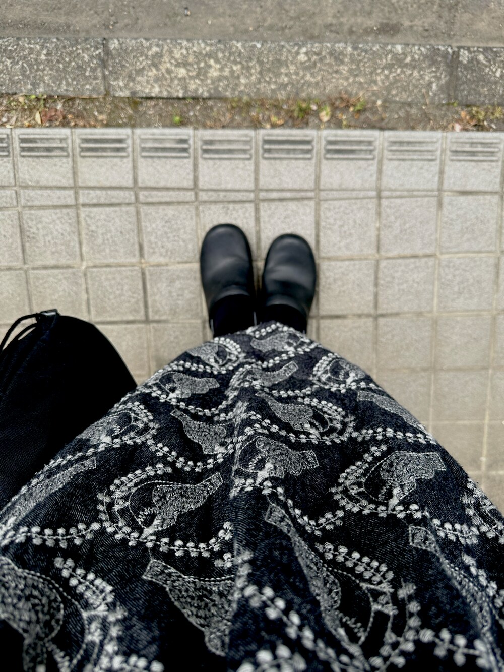 ブラック系のTシャツ/カットソー、ブラック系のベスト、ブラック系のスカートを着用したレディースの春コーディネートの2枚目の写真