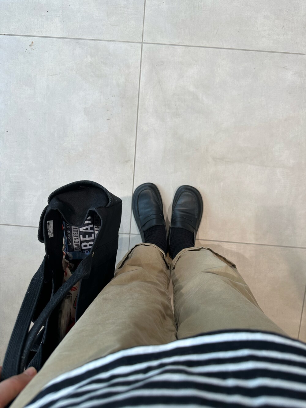 ブラック系のTシャツ/カットソー、ベージュ系のチノパンツ、ブラック系のローファーを着用したレディースの夏コーディネートの2枚目の写真