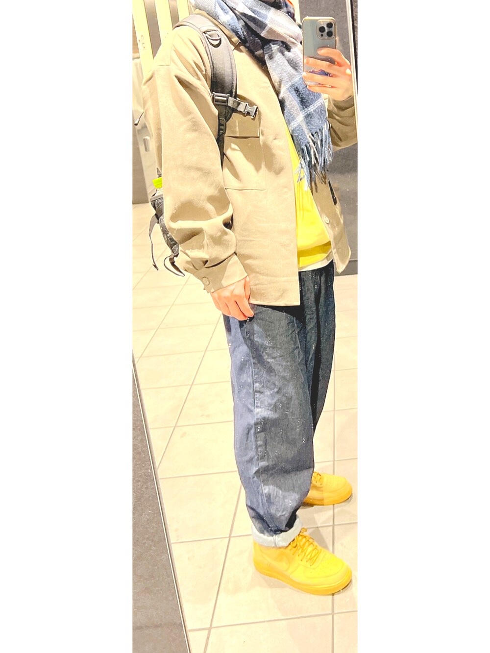 ブルー系のデニムパンツ、ベージュ系のスニーカー、ブラウン系のジャケット/アウターを着用したメンズの春コーディネートの2枚目の写真