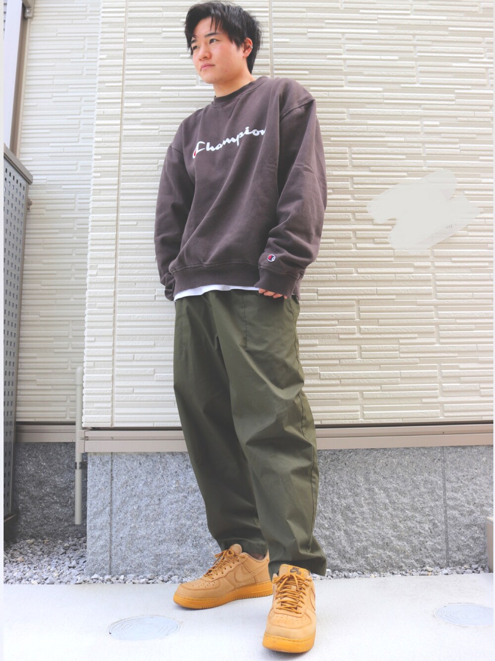 グリーン系のパンツ、ベージュ系のスニーカー、ブラウン系のスウェットを着用したメンズの春コーディネートの2枚目の写真