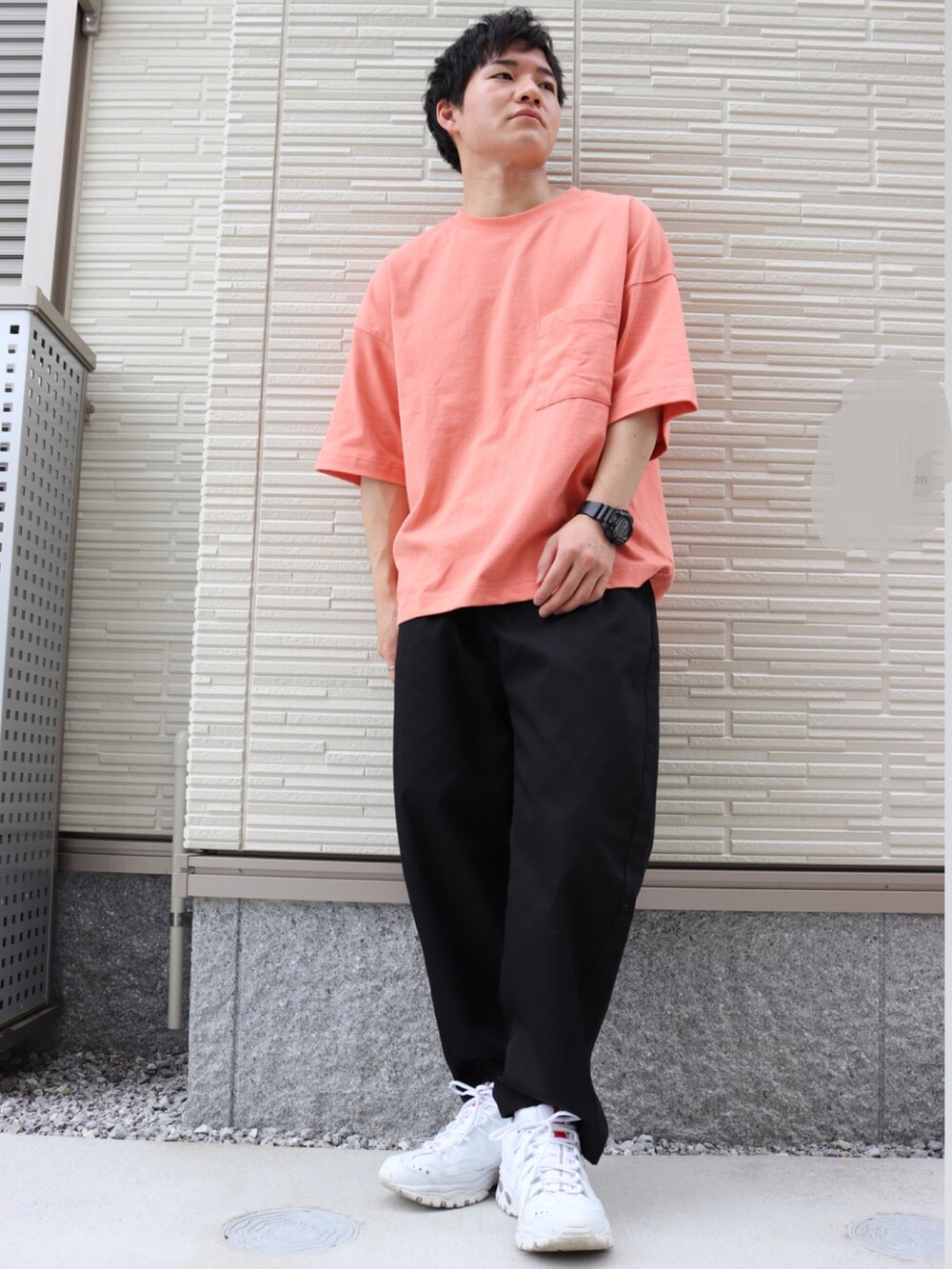 オレンジ系のTシャツ/カットソー、ブラック系のパンツ、グレー系のスニーカーを着用したメンズの夏コーディネートの2枚目の写真