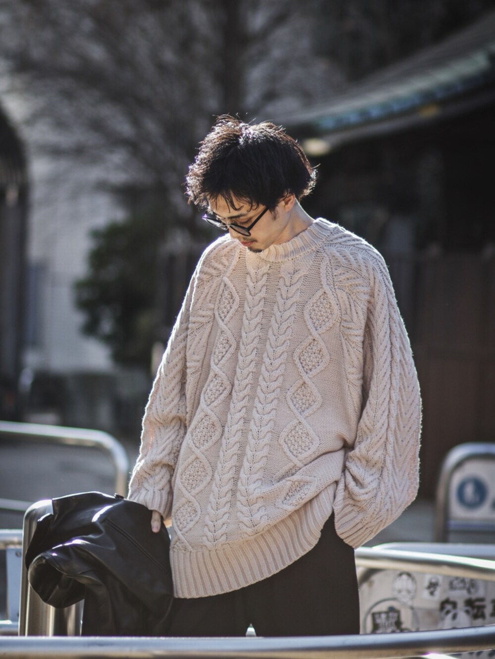 ブラック系のブルゾン、ホワイト系のニット/セーターを着用したメンズの冬コーディネートの2枚目の写真