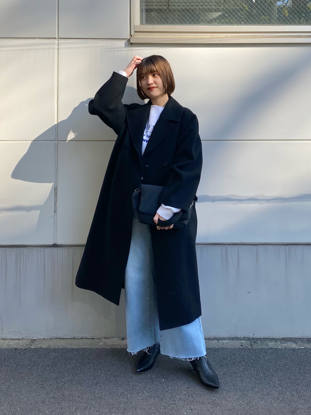 ブラック系のその他アウター、ブルー系のデニムパンツ、ブラック系のブーツを着用したレディースの冬コーディネートの2枚目の写真