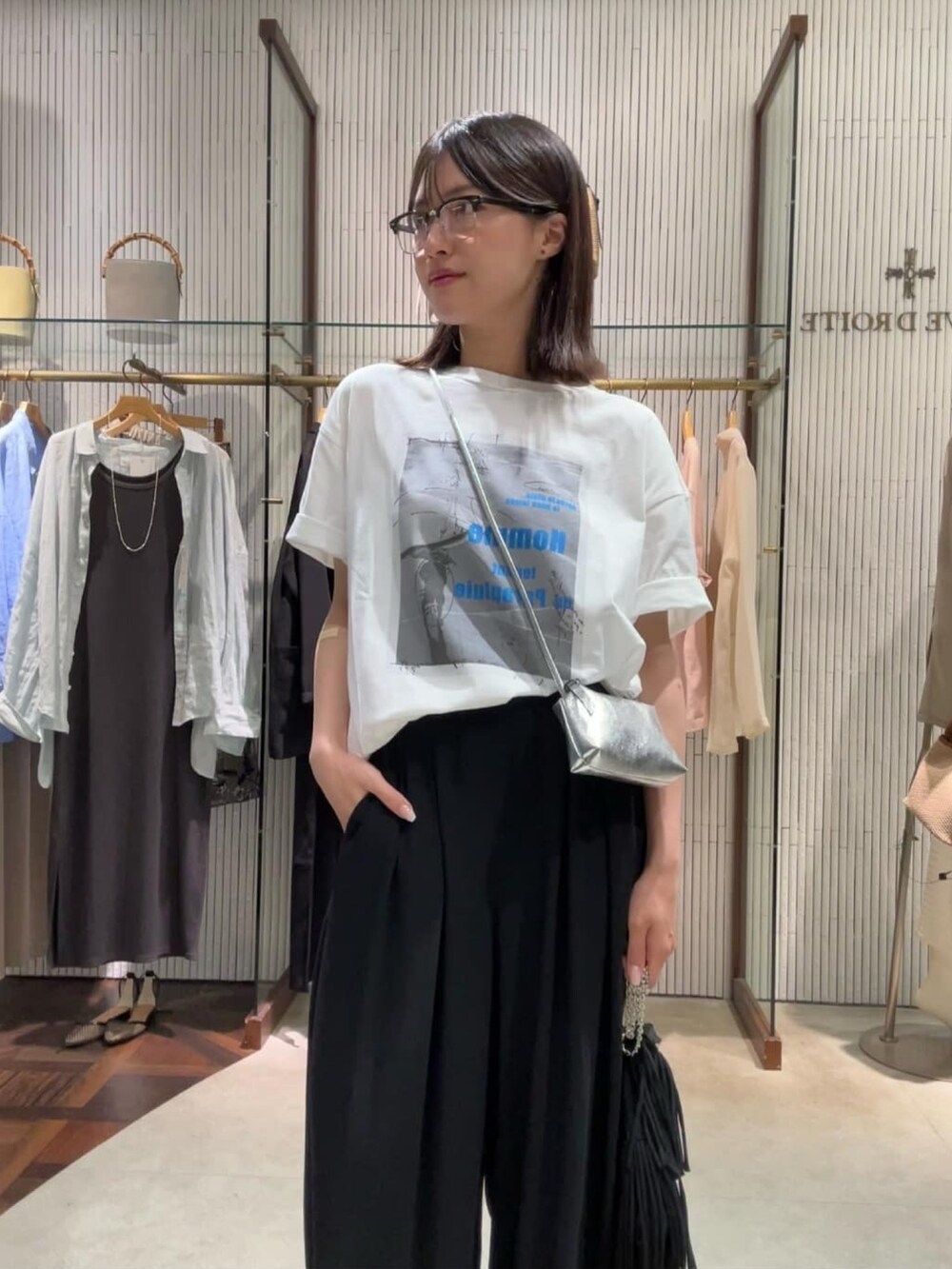 ブラック系のスラックス、ブラック系のサングラスを着用したレディースの夏コーディネートの4枚目の写真