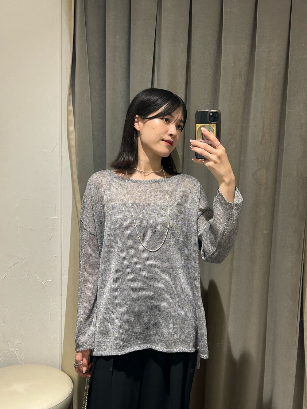 グレー系のニット/セーター、ブラック系のスラックス、シルバー系のネックレスを着用したレディースの夏コーディネートの3枚目の写真