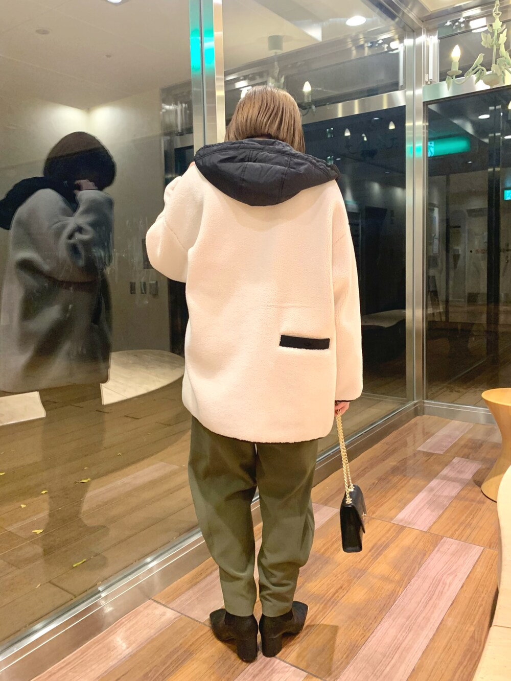 ホワイト系のその他アウター、グリーン系のカーゴパンツ、ブラック系のブーツを着用したレディースの冬コーディネートの3枚目の写真