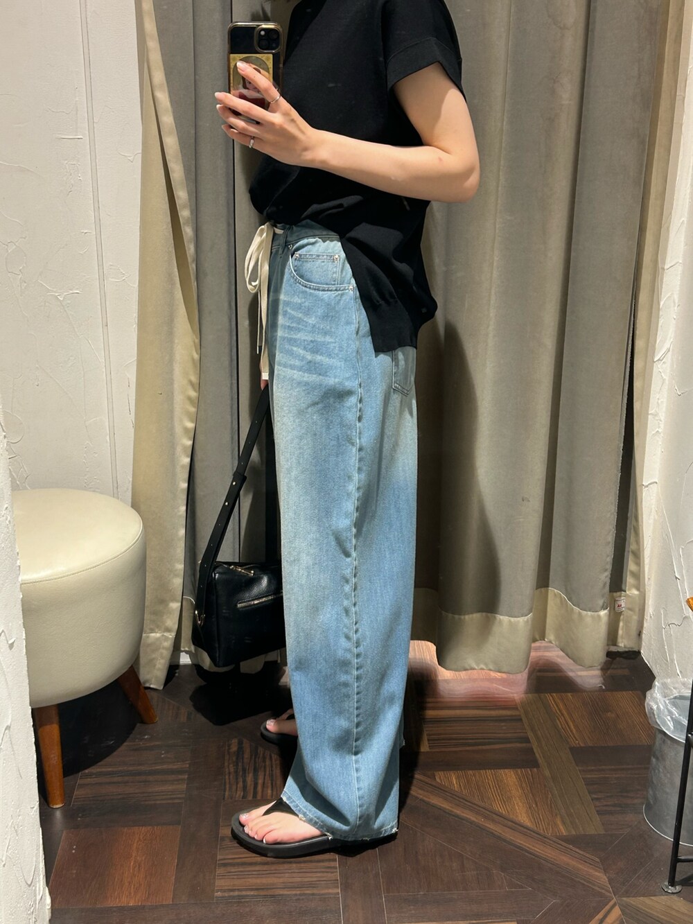 ブラック系のニット/セーター、ブルー系のデニムパンツ、ブラック系のボディバッグ/ウエストポーチを着用したレディースの夏コーディネートの6枚目の写真