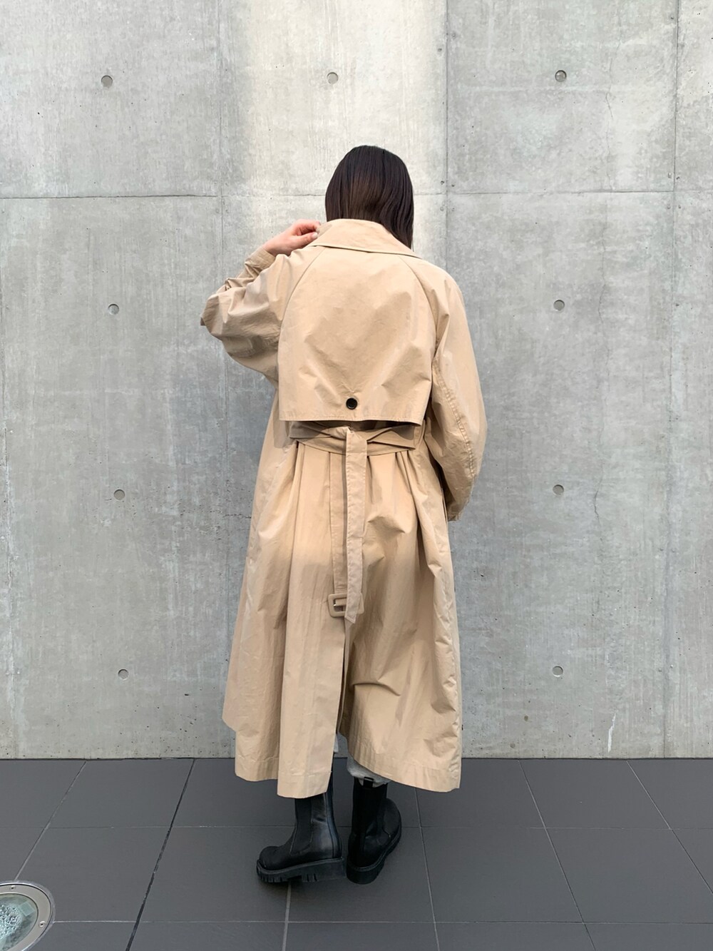 ベージュ系のトレンチコート、ホワイト系のTシャツ/カットソー、グレー系のスウェットパンツを着用したレディースの冬コーディネートの3枚目の写真