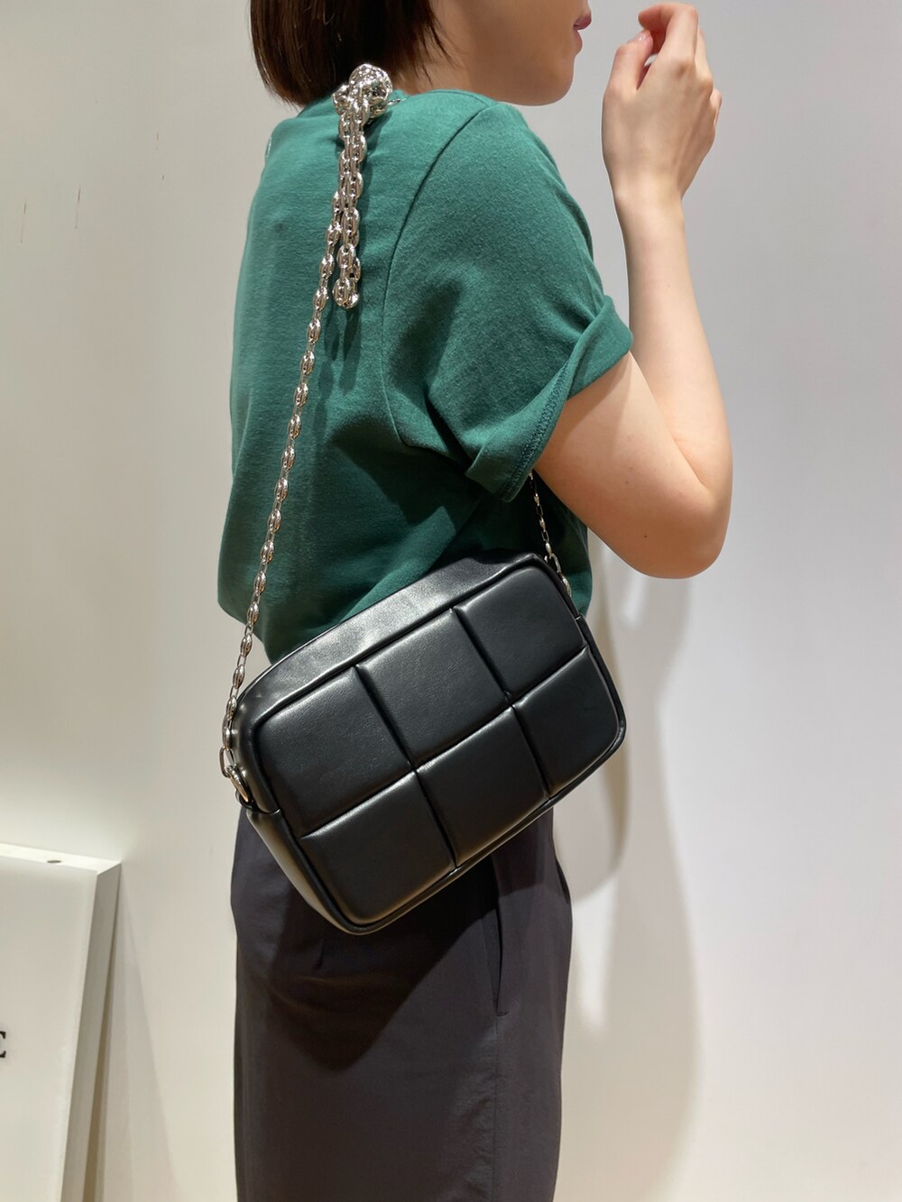 グリーン系のTシャツ/カットソー、ブラック系のショルダーバッグ、ブラック系のスカートを着用したレディースの夏コーディネートの3枚目の写真