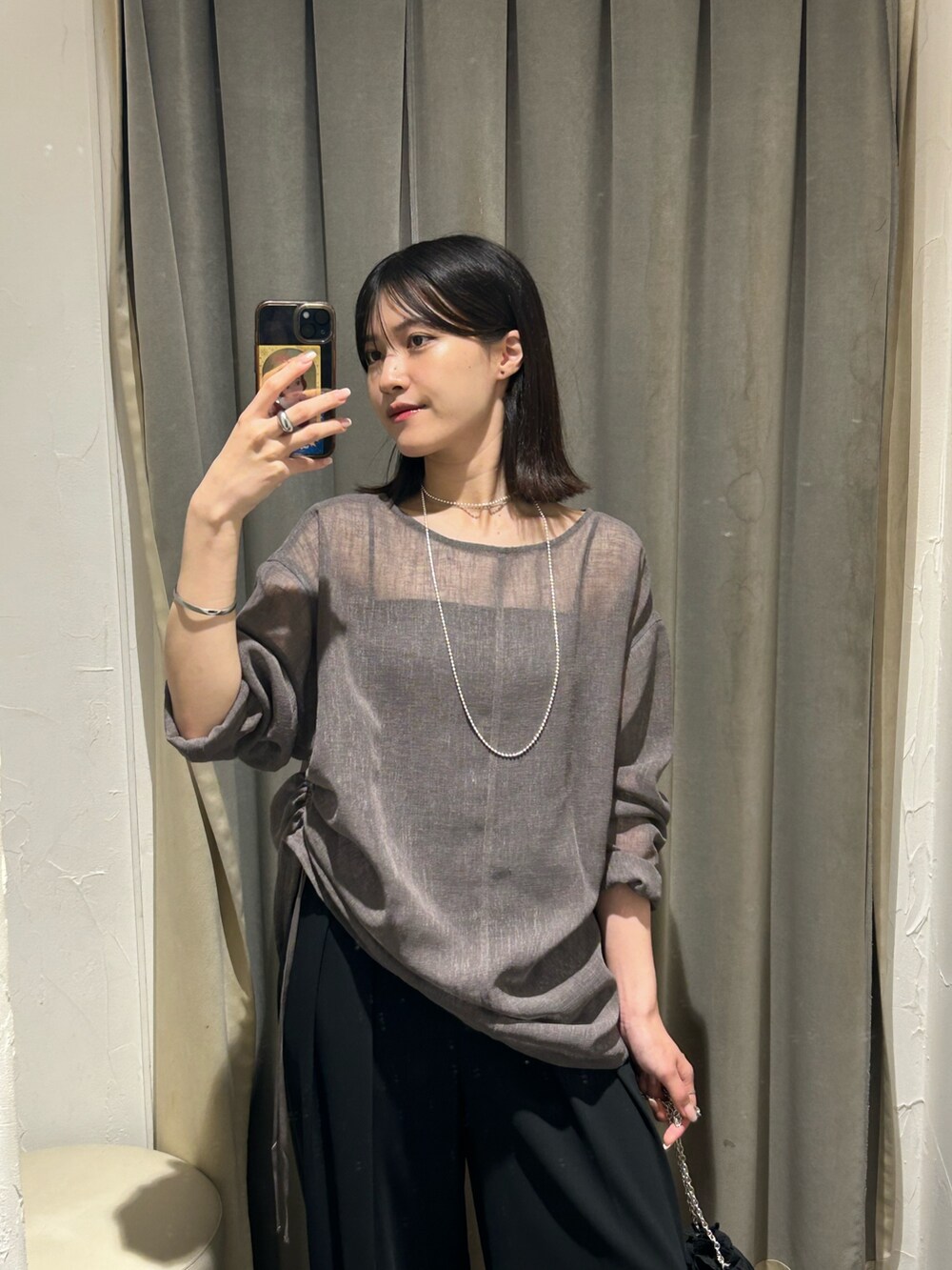 グレー系のシャツ/ブラウス、ブラック系のスラックス、シルバー系のネックレスを着用したレディースの夏コーディネートの3枚目の写真