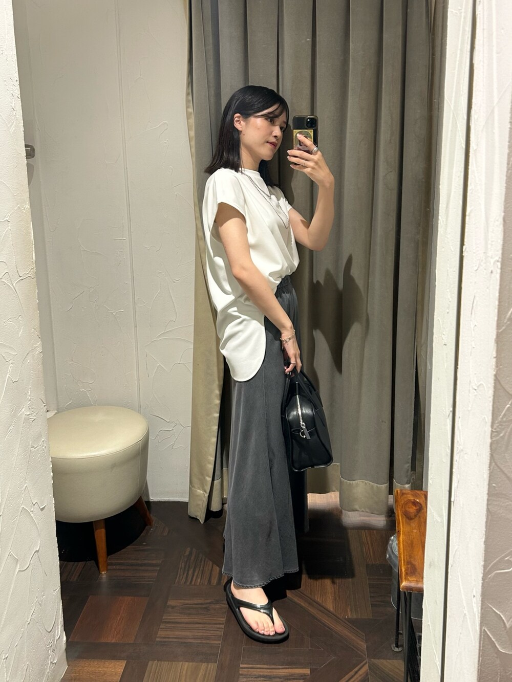 ホワイト系のTシャツ/カットソー、ブラック系のスカート、シルバー系のネックレスを着用したレディースの夏コーディネートの2枚目の写真