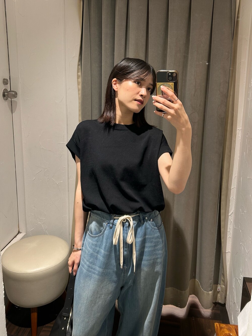 ブラック系のニット/セーター、ブルー系のデニムパンツ、ブラック系のボディバッグ/ウエストポーチを着用したレディースの夏コーディネートの3枚目の写真