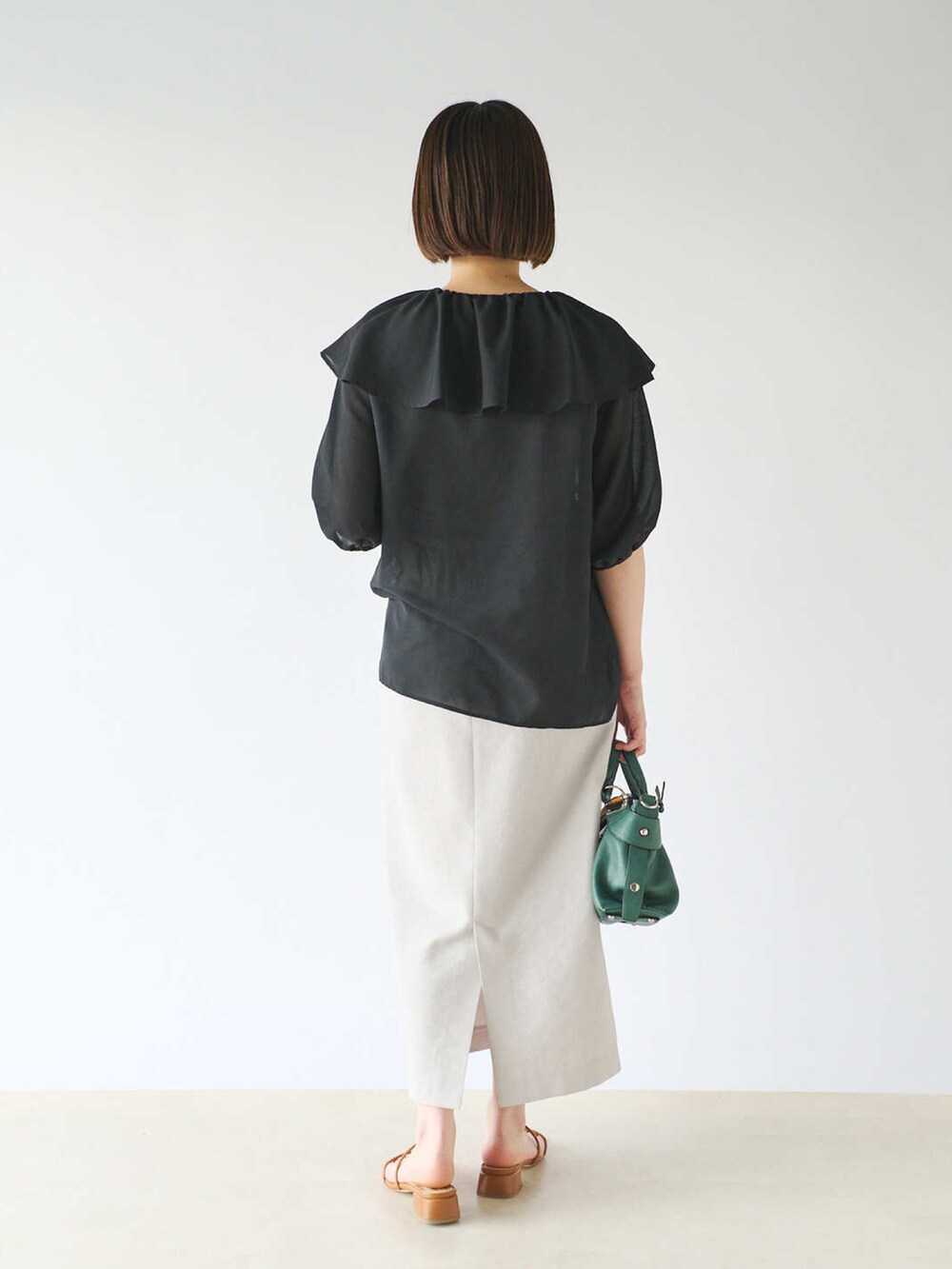 ブラック系のシャツ/ブラウス、グレー系のスカート、グリーン系のショルダーバッグを着用したレディースの春コーディネートの3枚目の写真