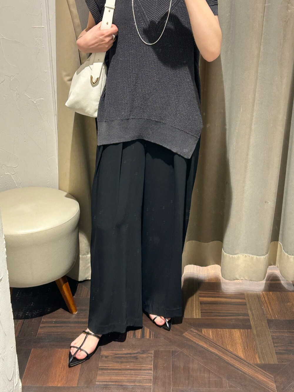 グレー系のニット/セーター、ブラック系のスラックス、ホワイト系のボディバッグ/ウエストポーチを着用したレディースの夏コーディネートの5枚目の写真