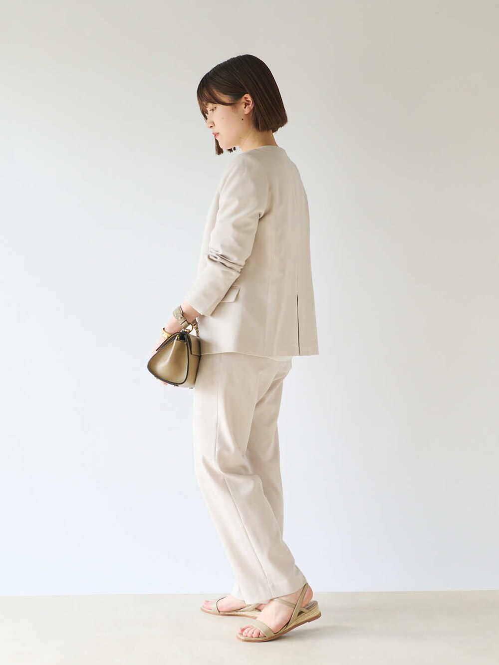 ホワイト系のシャツ/ブラウス、ベージュ系のテーラードジャケット、グレー系のショルダーバッグを着用したレディースの春コーディネートの3枚目の写真