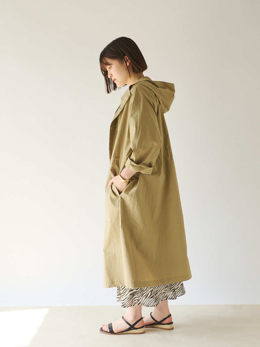 ホワイト系のTシャツ/カットソー、グリーン系のモッズコート、ブラウン系のスカートを着用したレディースの春コーディネートの2枚目の写真