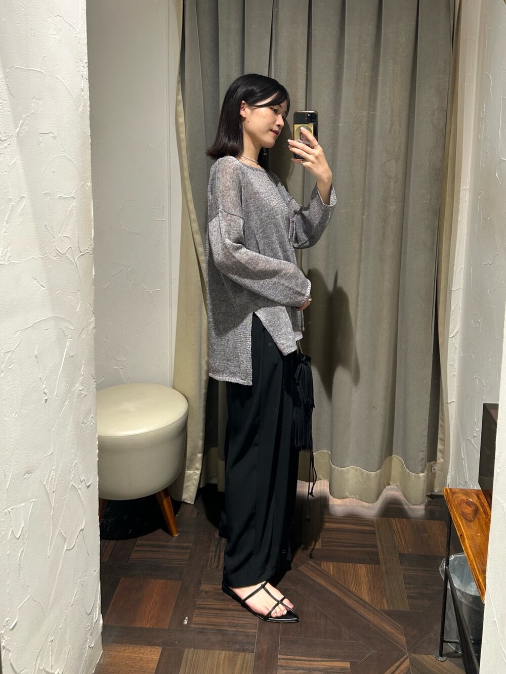 グレー系のニット/セーター、ブラック系のスラックス、シルバー系のネックレスを着用したレディースの夏コーディネートの2枚目の写真