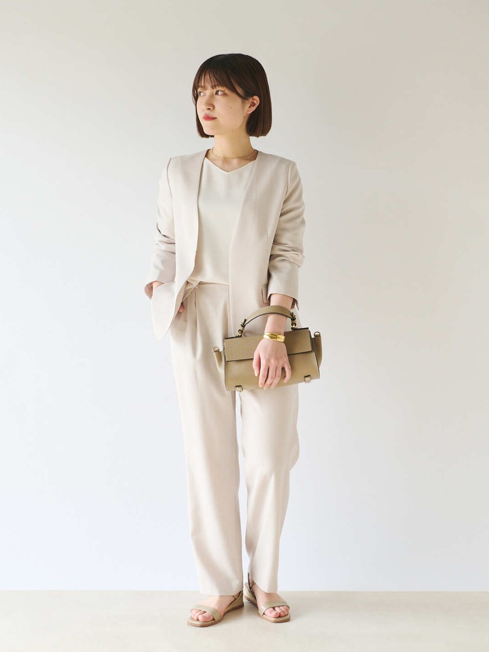 ホワイト系のシャツ/ブラウス、ベージュ系のテーラードジャケット、グレー系のショルダーバッグを着用したレディースの春コーディネートの2枚目の写真
