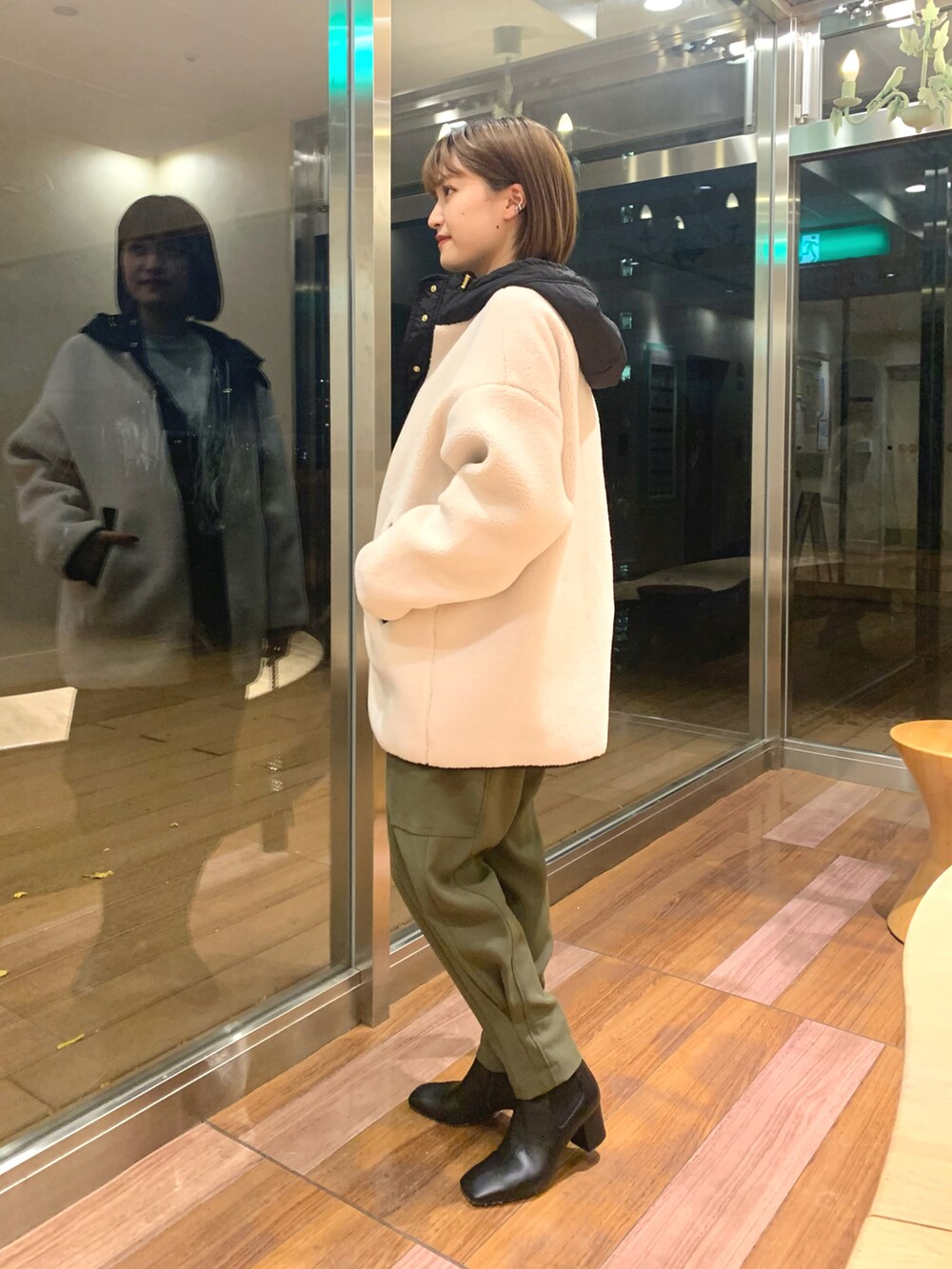 ホワイト系のその他アウター、グリーン系のカーゴパンツ、ブラック系のブーツを着用したレディースの冬コーディネートの2枚目の写真