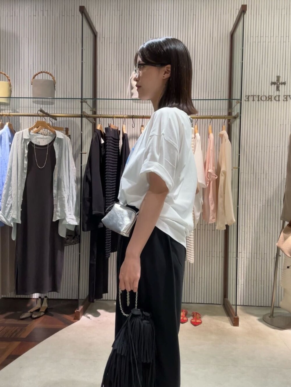 ブラック系のスラックス、ブラック系のサングラスを着用したレディースの夏コーディネートの5枚目の写真