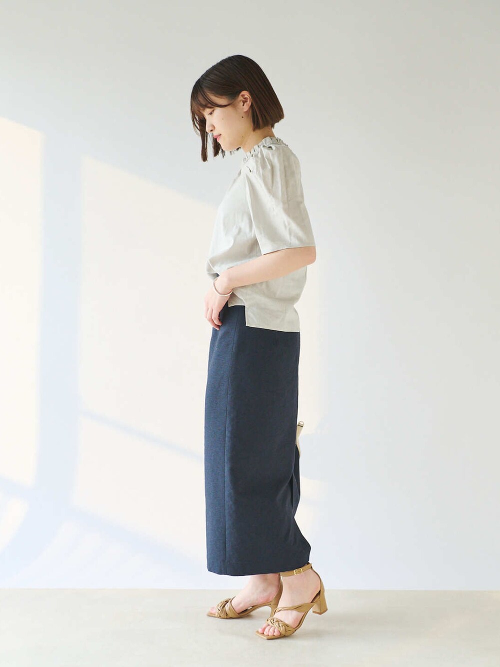 グレー系のシャツ/ブラウス、ホワイト系のショルダーバッグ、ブルー系のスカートを着用したレディースの春コーディネートの2枚目の写真