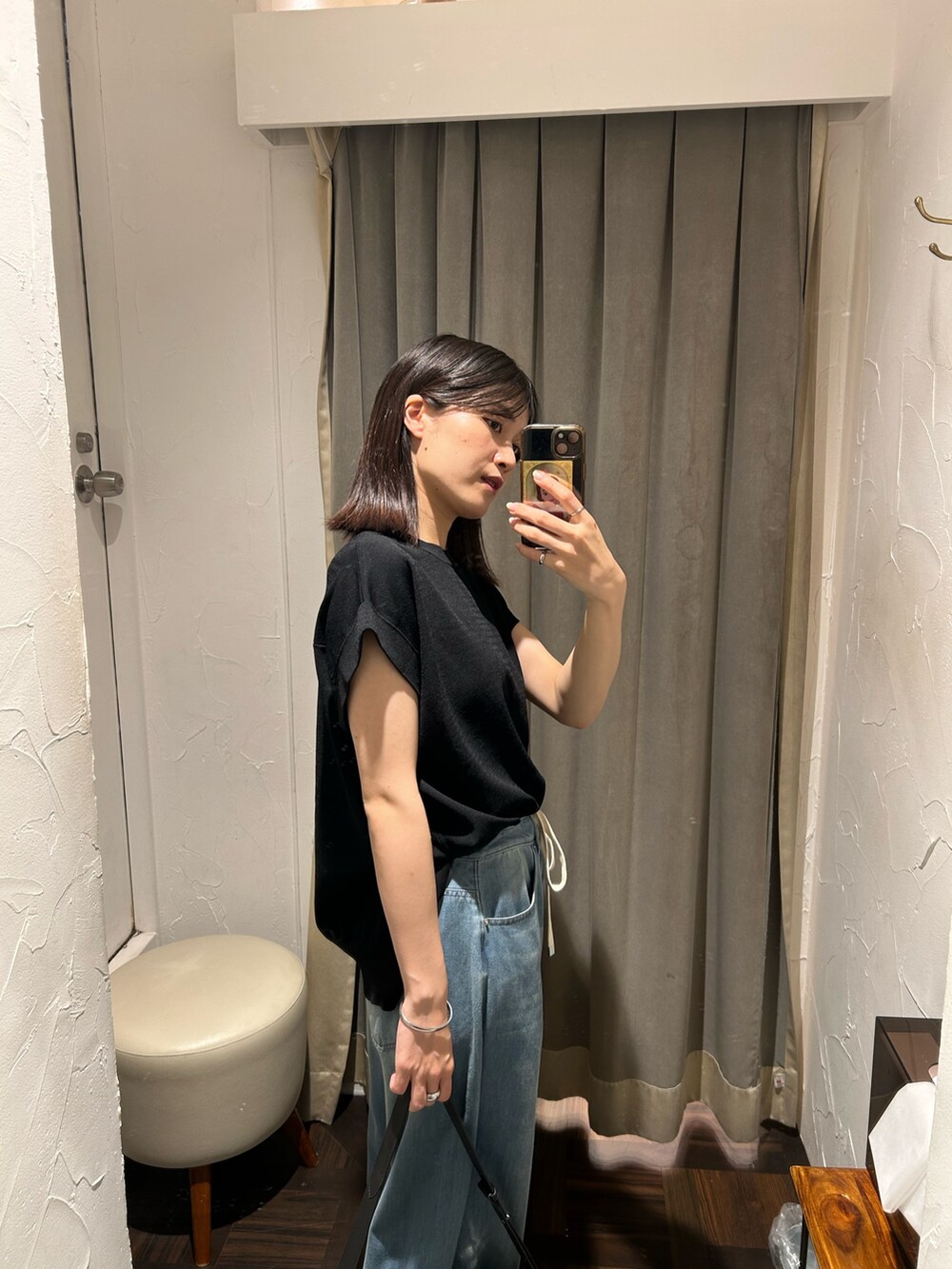 ブラック系のニット/セーター、ブルー系のデニムパンツ、ブラック系のボディバッグ/ウエストポーチを着用したレディースの夏コーディネートの4枚目の写真