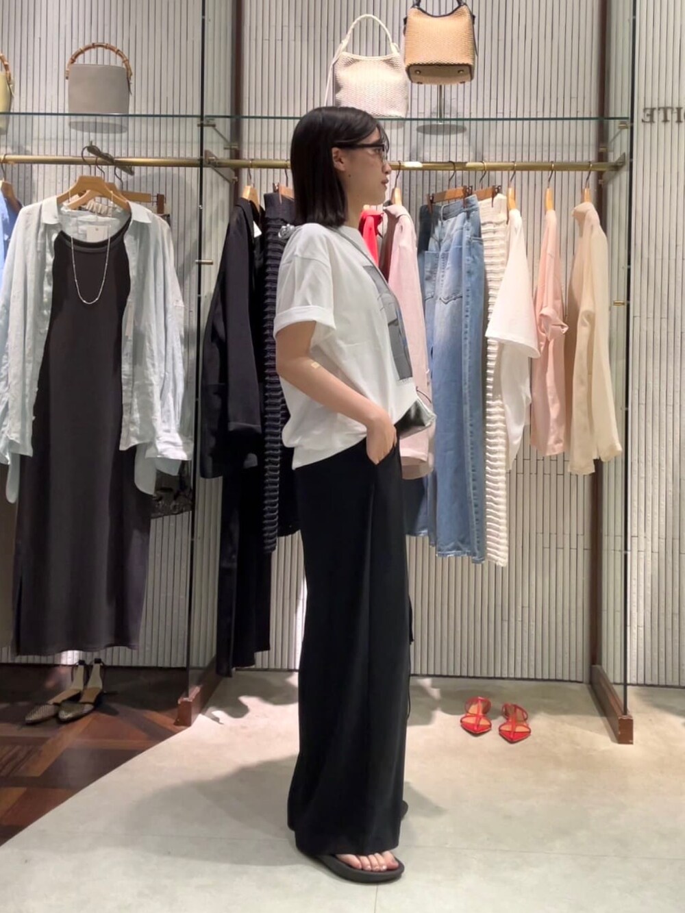 ブラック系のスラックス、ブラック系のサングラスを着用したレディースの夏コーディネートの2枚目の写真