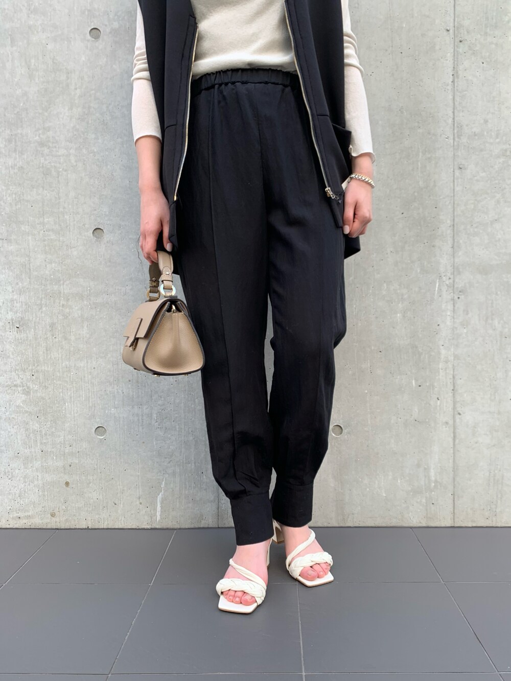 ブラック系のベスト、ホワイト系のTシャツ/カットソー、グレー系のショルダーバッグを着用したレディースの冬コーディネートの5枚目の写真