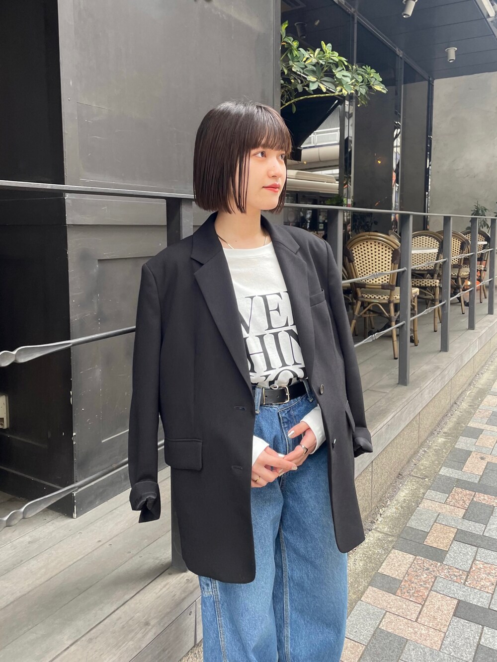 ブラック系のテーラードジャケット、ホワイト系のTシャツ/カットソー、ブルー系のデニムパンツを着用したレディースの春コーディネートの2枚目の写真