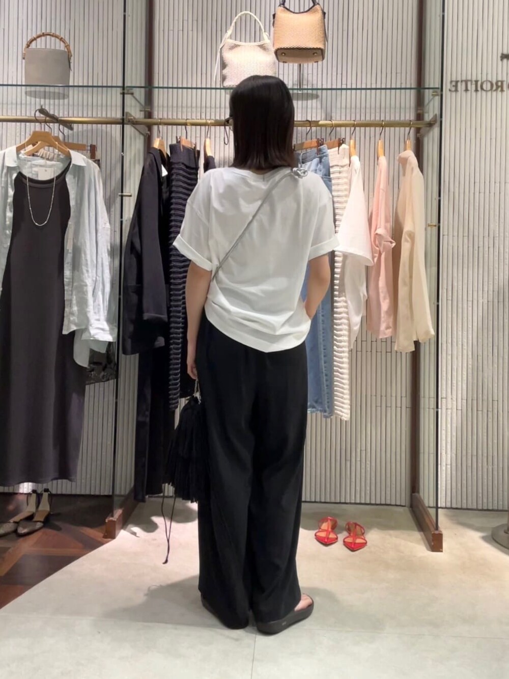 ブラック系のスラックス、ブラック系のサングラスを着用したレディースの夏コーディネートの3枚目の写真