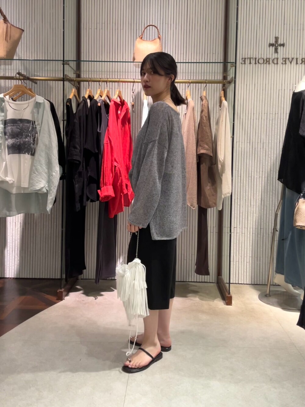 グレー系のニット/セーター、ブラック系のその他パンツ、シルバー系のネックレスを着用したレディースの夏コーディネートの2枚目の写真