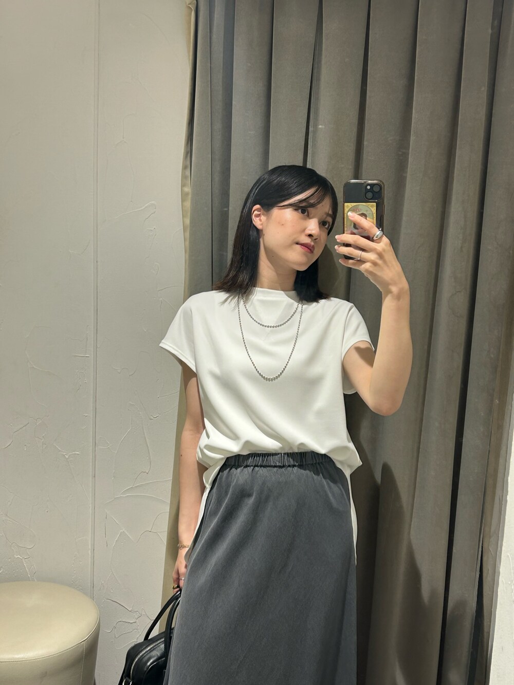 ホワイト系のTシャツ/カットソー、ブラック系のスカート、シルバー系のネックレスを着用したレディースの夏コーディネートの3枚目の写真