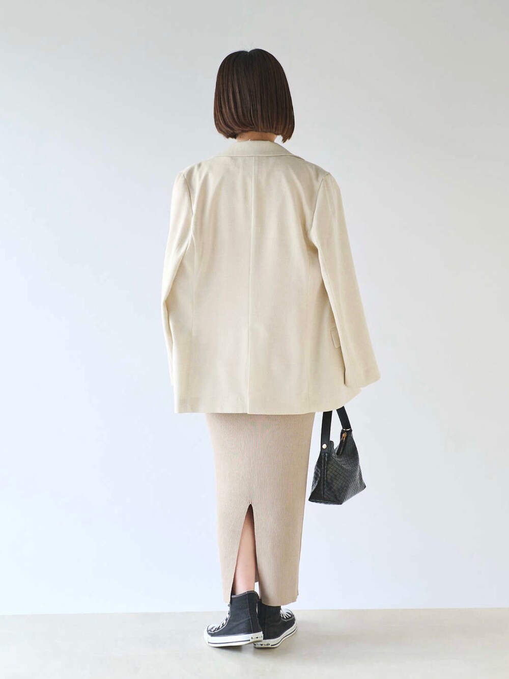 ピンク系のTシャツ/カットソー、イエロー系のテーラードジャケット、ベージュ系のスカートを着用したレディースの春コーディネートの3枚目の写真