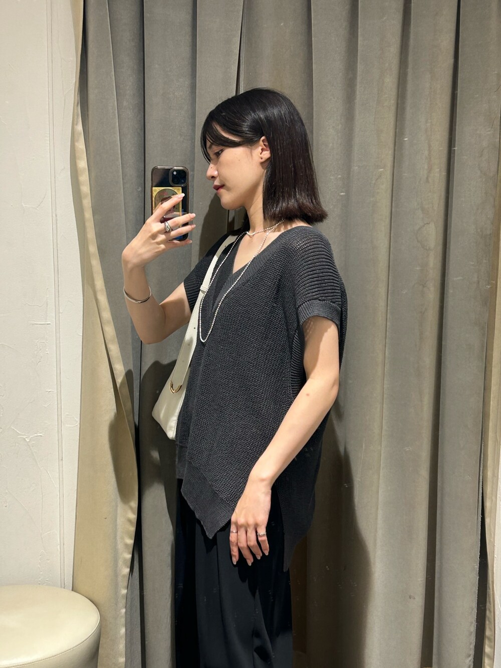 グレー系のニット/セーター、ブラック系のスラックス、ホワイト系のボディバッグ/ウエストポーチを着用したレディースの夏コーディネートの4枚目の写真