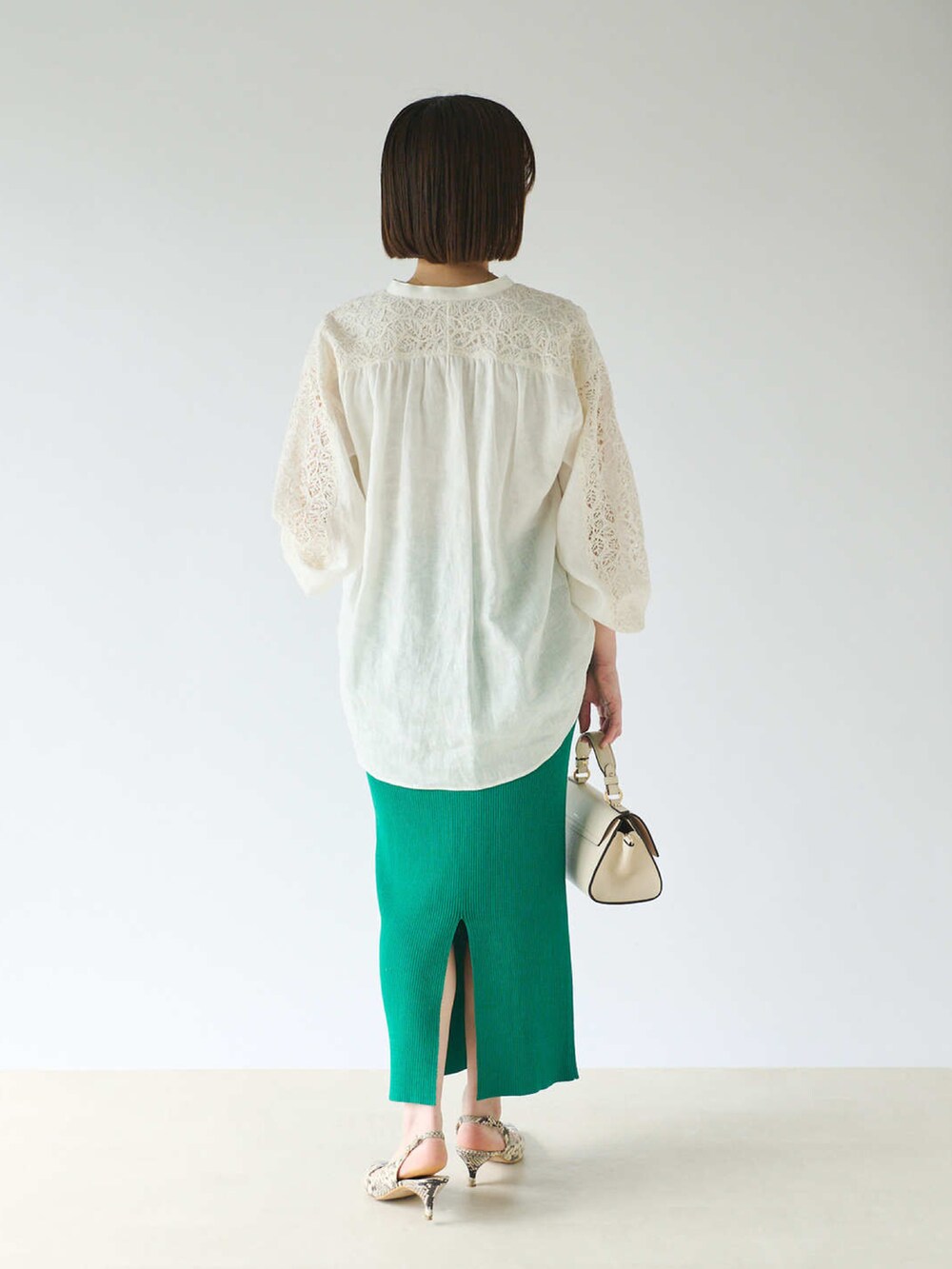 ホワイト系のシャツ/ブラウス、ホワイト系のショルダーバッグ、グリーン系のスカートを着用したレディースの春コーディネートの3枚目の写真