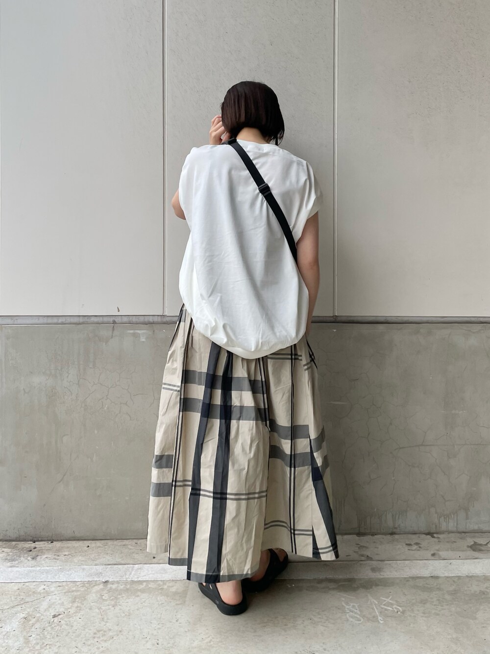 ブラック系のボディバッグ/ウエストポーチ、ホワイト系のスカート、ブラック系のサンダルを着用したレディースの春コーディネートの3枚目の写真