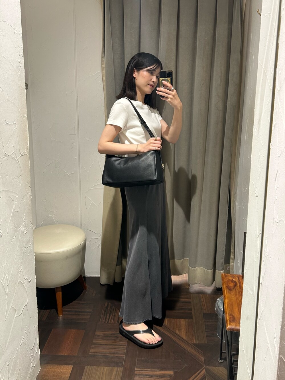 ブラック系のスカート、ブラック系のボディバッグ/ウエストポーチ、ホワイト系のTシャツ/カットソーを着用したレディースの夏コーディネートの2枚目の写真